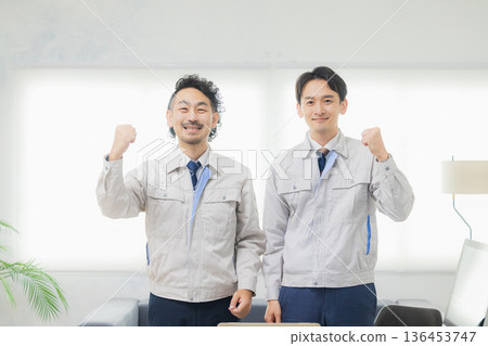 A man in work clothes making a guts pose A man in work clothes making a guts pose 136453747