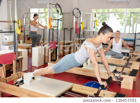 Young woman training her abs on pilates reformer 136453781
