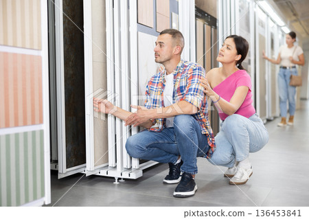 Couple of man and woman choose tiles in store 136453841