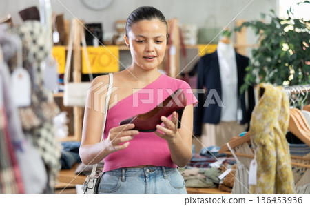 Asian woman customer turn over and choose high heels shoes in store Asian woman customer turn over and choose high heels shoes in store 136453936