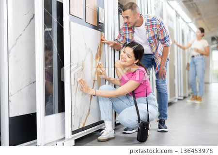 Couple of man and woman choose tiles in store Couple of man and woman choose tiles in store 136453978