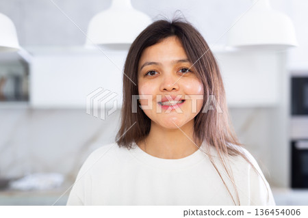 Closeup portrait of pleasant smiling dark-haired young woman Closeup portrait of pleasant smiling dark-haired young woman 136454006