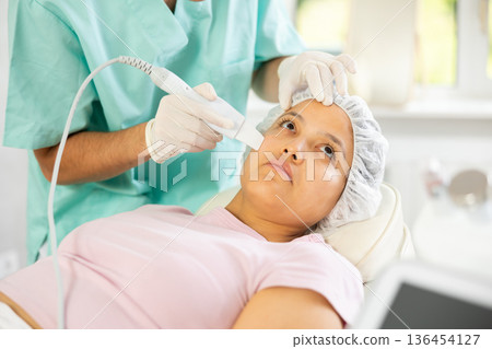dermatologist deftly wields skin scrubber 136454127