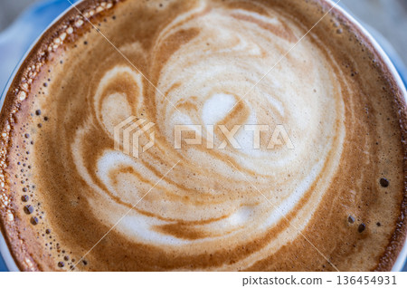 Close up of the surface of hot latte coffee. A latte is a coffee drink made with espresso and steamed milk. 136454931