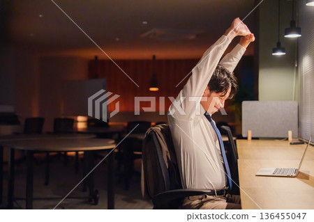 一名年輕的男員工加班到深夜。 一名年輕的男員工加班到深夜。 136455047