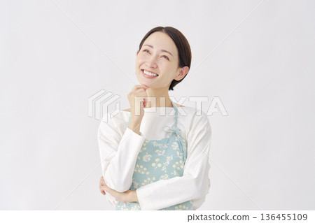 身穿圍裙的女子，正在想像，白色背景 136455109
