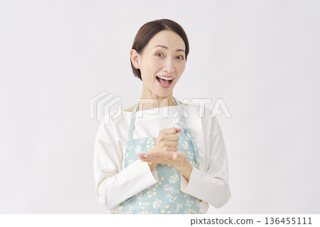 A woman wearing an apron is convinced, white background A woman wearing an apron is convinced, white background 136455111