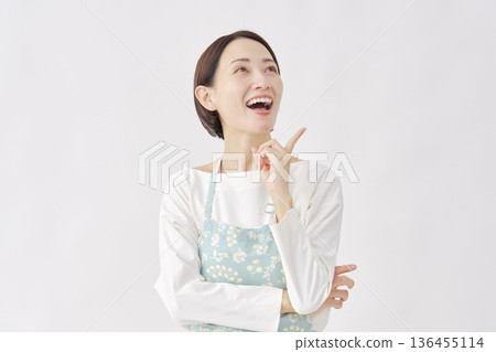 一位穿著圍裙的女士突然有了個主意。白色背景 136455114