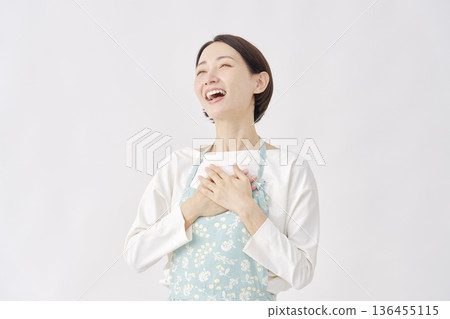 身穿圍裙的女子，神情如釋重負，白色背景 136455115