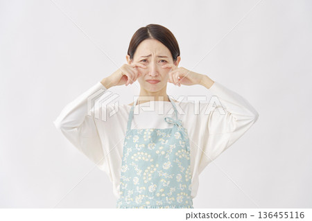 白色背景上的哭泣女子，穿著圍裙 136455116