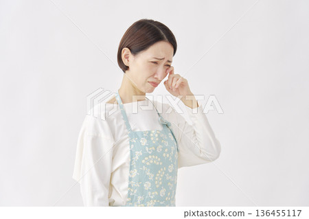 白色背景上的哭泣女子，穿著圍裙 136455117