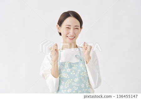 Woman wearing an apron, fist pump, white background Woman wearing an apron, fist pump, white background 136455147