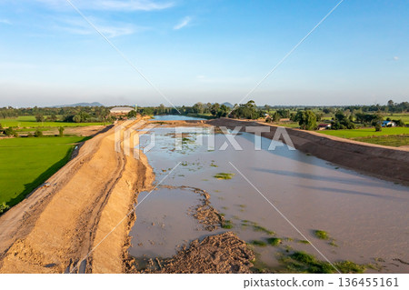 Construction dredges up for a canal and dam, to prevent a flood in the rainy season. Date on 14 May 2021 at Uthai Thani province, Thailand. 136455161