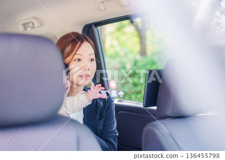 Busy mother taking a taxi with her child Busy mother taking a taxi with her child 136455798