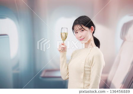 一名女子在飛機商務艙內喝葡萄酒 一名女子在飛機商務艙內喝葡萄酒 136456889