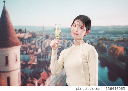 A woman drinking wine elegantly while traveling abroad 136457065