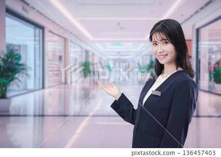 一位女員工在購物中心指引方向 一位女員工在購物中心指引方向 136457403