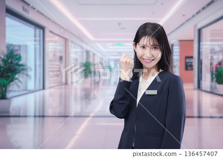 A female staff member giving directions at a shopping mall A female staff member giving directions at a shopping mall 136457407
