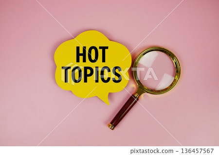 Hot Topics text on speech bubble with magnifying glass on pink background 136457567