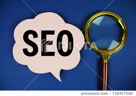 SEO (Search Engine Optimization) text on speech bubble with magnifying glass on navy blue background 136457580