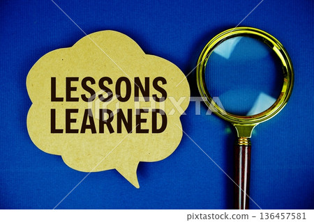 Lessons Learned text on speech bubble with magnifying glass on navy blue background Lessons Learned text on speech bubble with magnifying glass on navy blue background 136457581