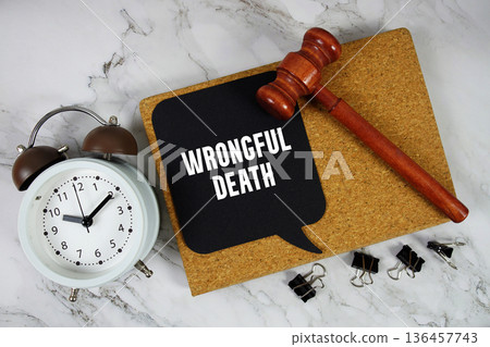 Wrongful Death text on speech bubble with alarm clock and wooden gavel on marble background 136457743