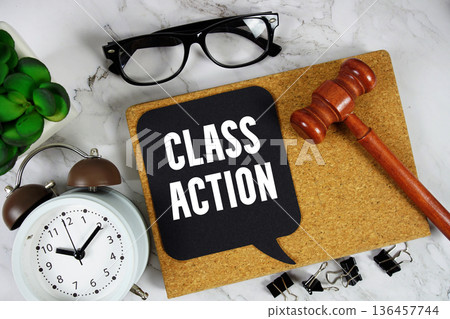 Class Action text on speech bubble with alarm clock and wooden gavel on marble background 136457744