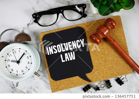 Insolvency Law text on speech bubble with alarm clock and wooden gavel on marble background Insolvency Law text on speech bubble with alarm clock and wooden gavel on marble background 136457751