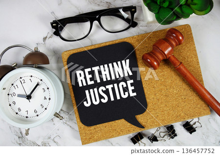 Rethink Justice text on speech bubble with alarm clock and wooden gavel on marble background Rethink Justice text on speech bubble with alarm clock and wooden gavel on marble background 136457752