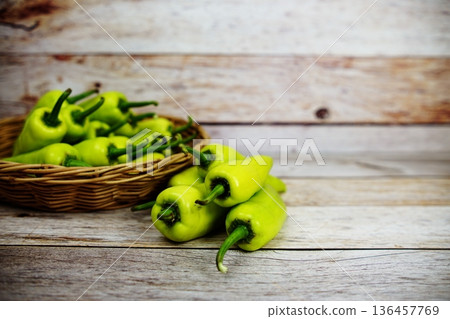 Fresh raw green bell pepper in bamboo basket on wooden background Fresh raw green bell pepper in bamboo basket on wooden background 136457769