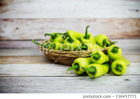 Fresh raw green bell pepper in bamboo basket on wooden background Fresh raw green bell pepper in bamboo basket on wooden background 136457771