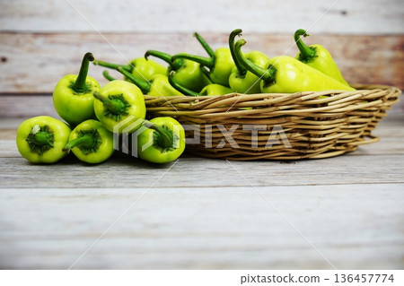 Fresh raw green bell pepper in bamboo basket on wooden background 136457774