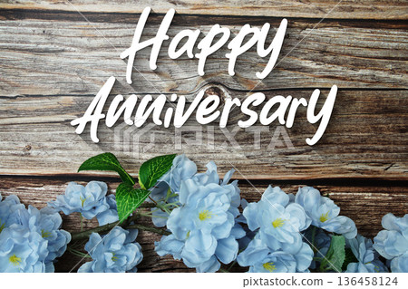 Happy Anniversary text with flowers decoration on wooden background Happy Anniversary text with flowers decoration on wooden background 136458124