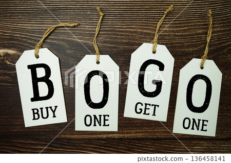 Price tag with "Buy One Get One" is placed on wooden background Price tag with "Buy One Get One" is placed on wooden background 136458141