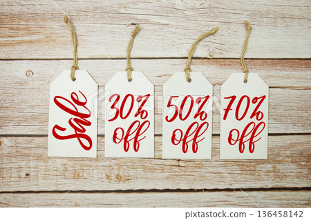 Price tag with "Sale 30%, 50% 70% off" is placed on wooden background Price tag with "Sale 30%, 50% 70% off" is placed on wooden background 136458142