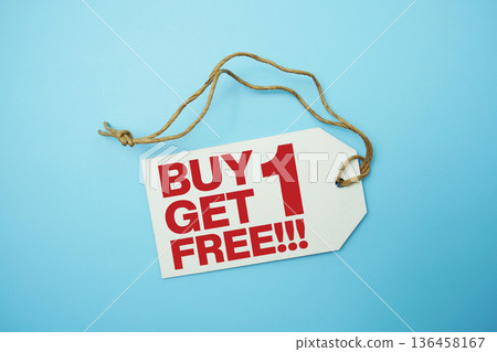 Price tag with "Buy 1 Get 1 Free!!!" is placed on blue background Price tag with "Buy 1 Get 1 Free!!!" is placed on blue background 136458167
