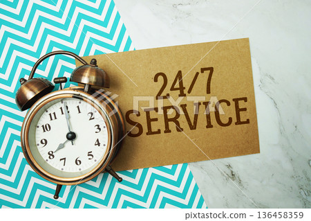 24 Hr 7 Service text written on paper card with alarm clock on marble background 24 Hr 7 Service text written on paper card with alarm clock on marble background 136458359