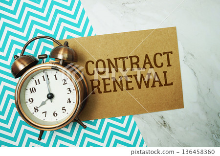 Contract Renewal text written on paper card with alarm clock on marble background 136458360