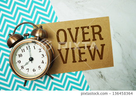 Over View text written on paper card with alarm clock on marble background 136458364