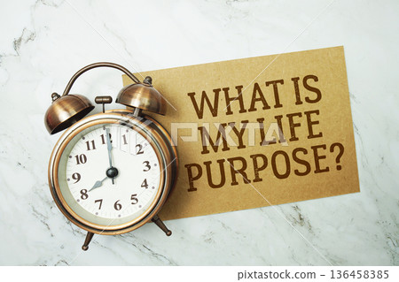 What Is My Life Purpose? text written on paper card with alarm clock on marble background 136458385