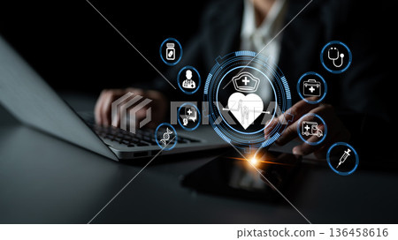 Professional Using Laptop and Smartphone for Healthcare Management and Digital Health Solutions with Innovative Medical Icons Displayed Quark 136458616