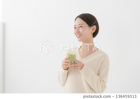 Woman drinking matcha latte Woman drinking matcha latte 136459313