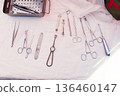 A set of surgical instrument on a white surface. 136460147