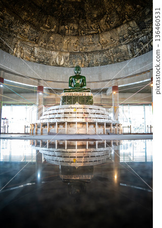The largest jade Buddha statue in the world is enshrined under the bronze dome with craving historic panels at Wat Dhamma Mongkol temple, Bangkok, Thailand. The largest jade Buddha statue in the world is enshrined under the bronze dome with craving historic panels at Wat Dhamma Mongkol temple, Bangkok, Thailand. 136460531