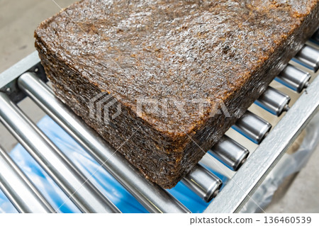 The natural rubber bales products on the industrial automatic conveyor belt machine in a rubber factory. 136460539