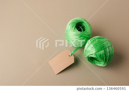 Two green spools of recycled polyester fiber with blank label indicating the product's eco-friendliness. Recycling, conscious waste management Two green spools of recycled polyester fiber with blank label indicating the product's eco-friendliness. Recycling, conscious waste management 136460591