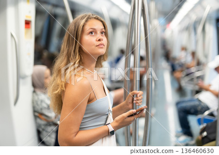 Young girl standing in wagon holding phone in hand Young girl standing in wagon holding phone in hand 136460630