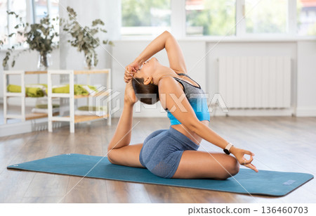 Young woman practicing vinyasa yoga in studio 136460703