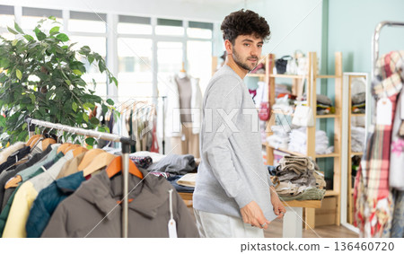Guy tries on turtleneck in clothing store Guy tries on turtleneck in clothing store 136460720