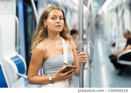 Young girl standing in wagon holding phone in hand Young girl standing in wagon holding phone in hand 136460818